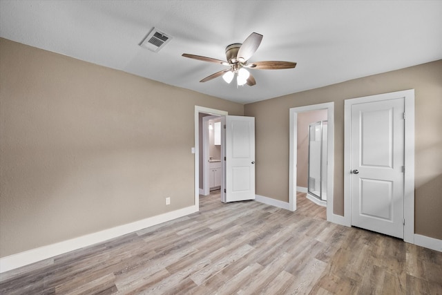 unfurnished bedroom featuring ceiling fan, ensuite bathroom, and light hardwood / wood-style flooring