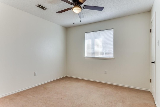 carpeted spare room featuring ceiling fan and a textured ceiling