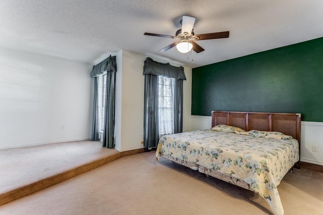 bedroom with carpet, a textured ceiling, and ceiling fan