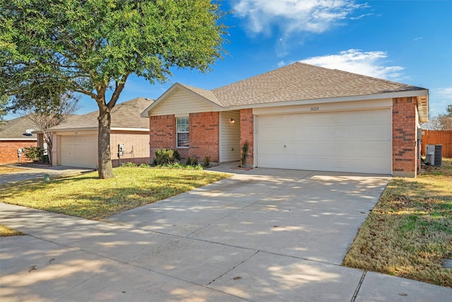 ranch-style home with a garage, central AC, and a front lawn