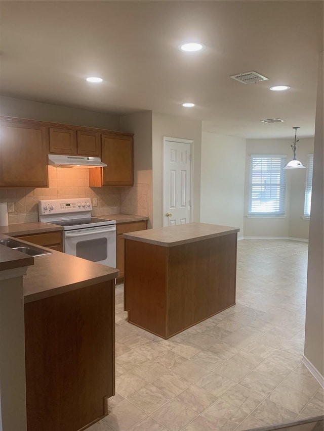 kitchen with a kitchen island, pendant lighting, sink, backsplash, and white electric range oven