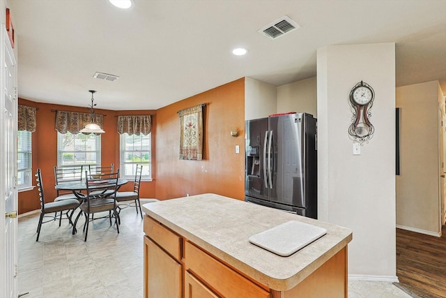 kitchen featuring pendant lighting, stainless steel fridge, and a center island