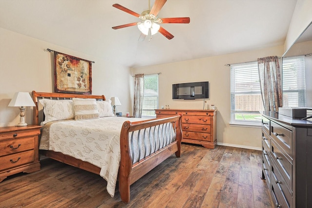 bedroom featuring ceiling fan, dark hardwood / wood-style flooring, vaulted ceiling, and multiple windows