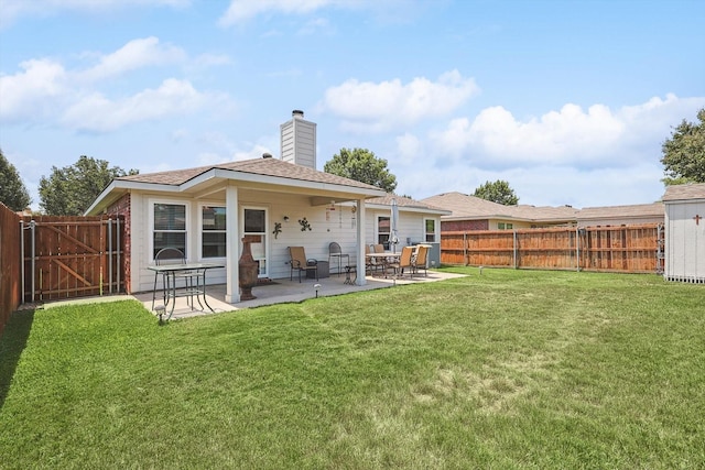 rear view of property featuring a patio area and a lawn