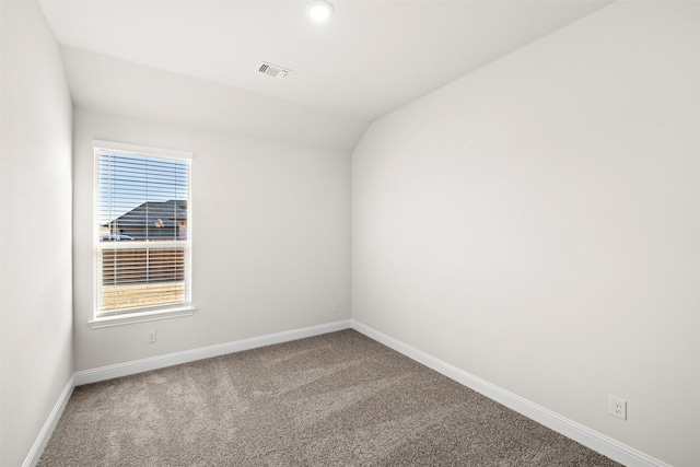 carpeted empty room with vaulted ceiling