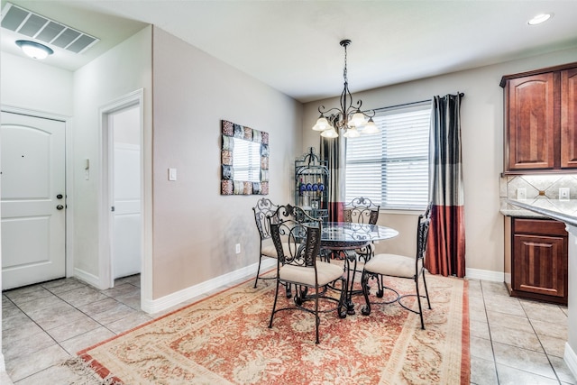 tiled dining area featuring a notable chandelier