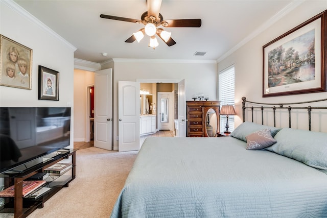 carpeted bedroom with ensuite bath, ornamental molding, and ceiling fan