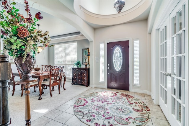 foyer with light carpet, french doors, and a healthy amount of sunlight