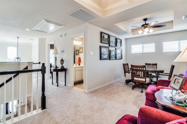 carpeted living room featuring ceiling fan and a raised ceiling