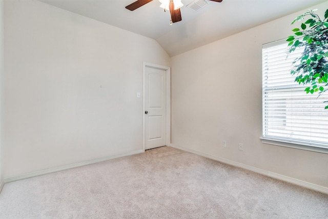 unfurnished room featuring ceiling fan, light colored carpet, lofted ceiling, and a wealth of natural light