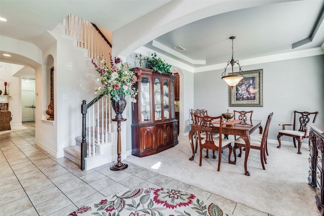 tiled dining room with a raised ceiling