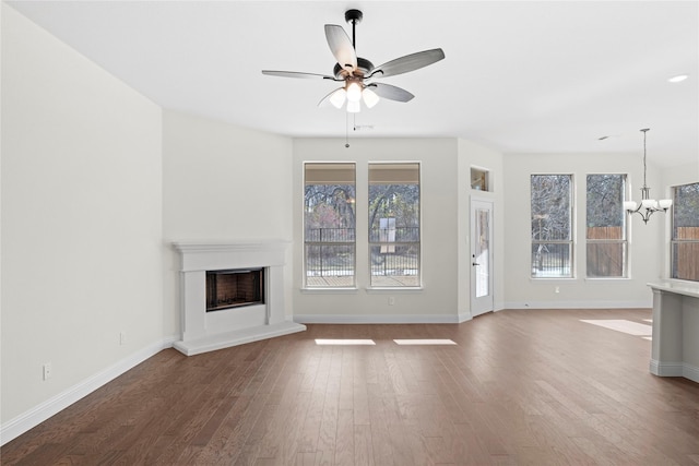 unfurnished living room featuring wood-type flooring and ceiling fan with notable chandelier