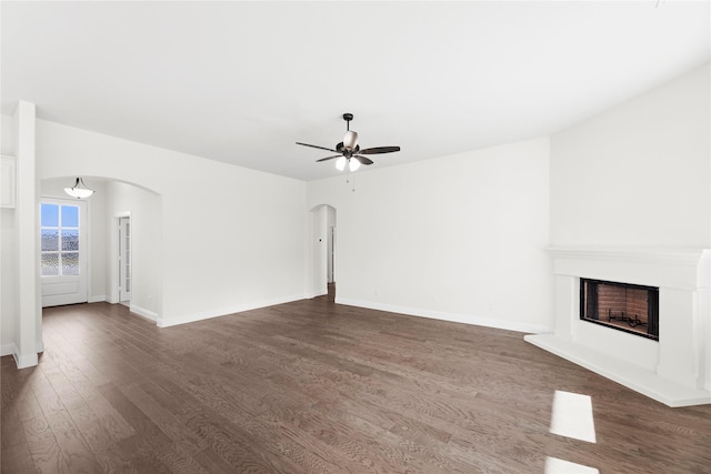 unfurnished living room featuring dark hardwood / wood-style flooring and ceiling fan