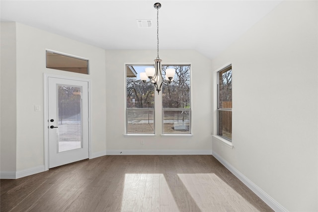 unfurnished dining area with vaulted ceiling, hardwood / wood-style floors, and a notable chandelier