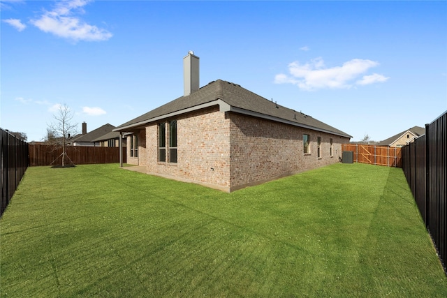 rear view of property with a yard and central air condition unit