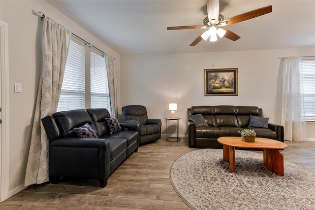 living room featuring baseboards, wood finished floors, and a ceiling fan