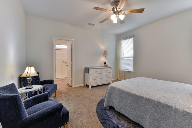 carpeted bedroom with ceiling fan and ensuite bath