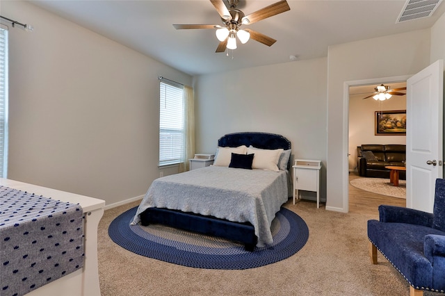 carpeted bedroom featuring visible vents, a ceiling fan, and baseboards