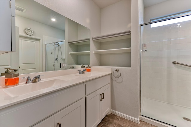 full bath with double vanity, visible vents, a stall shower, and a sink