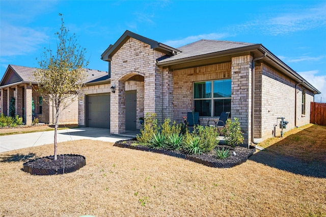 view of front of house with driveway, covered porch, a front yard, a garage, and brick siding