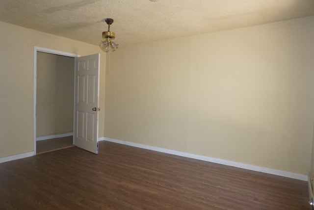 spare room with dark hardwood / wood-style flooring and a textured ceiling