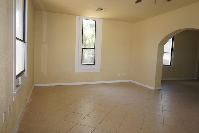 tiled spare room featuring ceiling fan