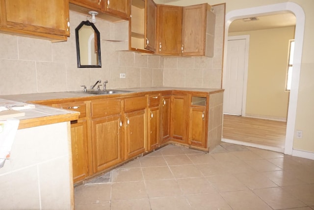 kitchen featuring tasteful backsplash, sink, and light tile patterned floors