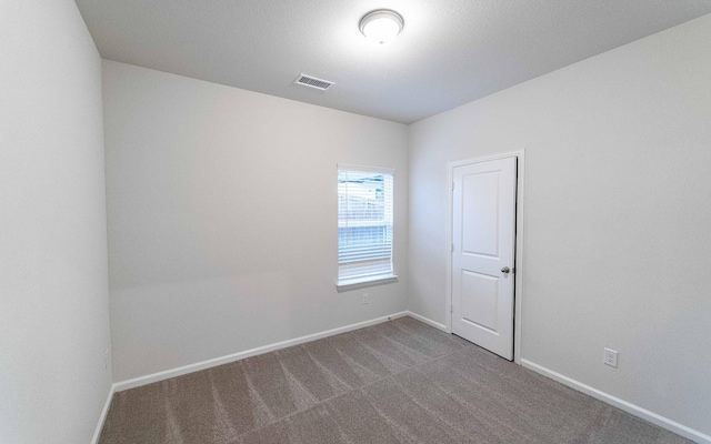 carpeted empty room featuring visible vents and baseboards