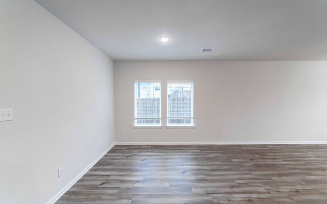 spare room with visible vents, baseboards, and wood finished floors