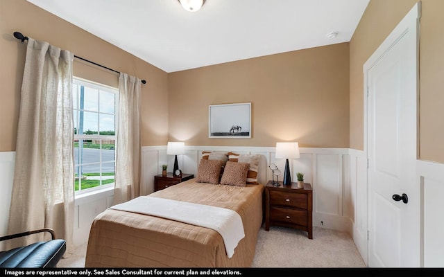 bedroom with light colored carpet and multiple windows