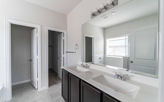 bathroom featuring double vanity, tile patterned flooring, visible vents, and a sink