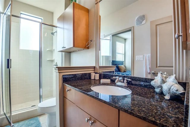 bathroom featuring vanity, plenty of natural light, a shower with door, and toilet