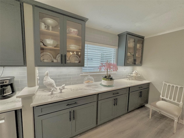 bar featuring tasteful backsplash, sink, gray cabinetry, and light wood-type flooring