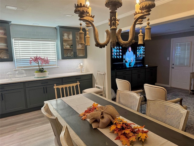 dining room with ornamental molding and light wood-type flooring