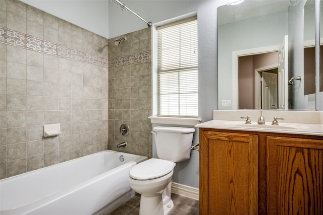 bathroom with tile patterned flooring, toilet, vanity, baseboards, and  shower combination