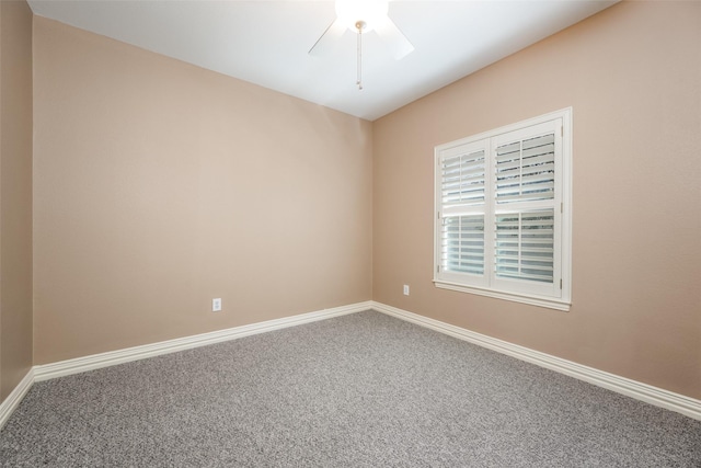 carpeted spare room featuring a ceiling fan and baseboards