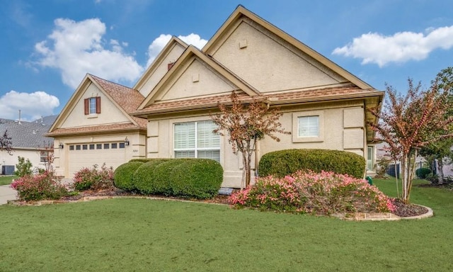 view of front of home with stucco siding, driveway, cooling unit, an attached garage, and a front lawn