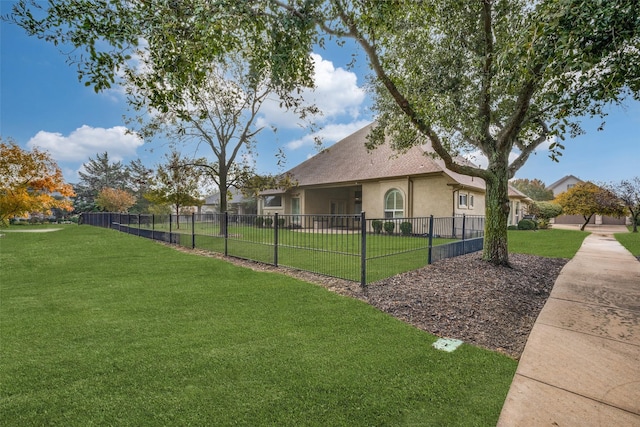 view of side of property with a lawn, fence private yard, and stucco siding