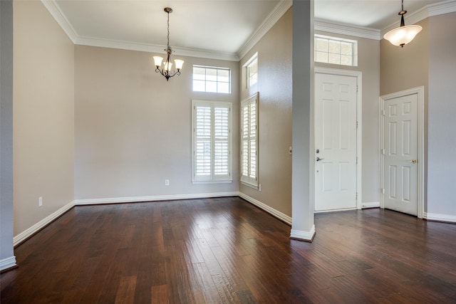 foyer entrance with dark wood-style flooring, a notable chandelier, crown molding, and baseboards