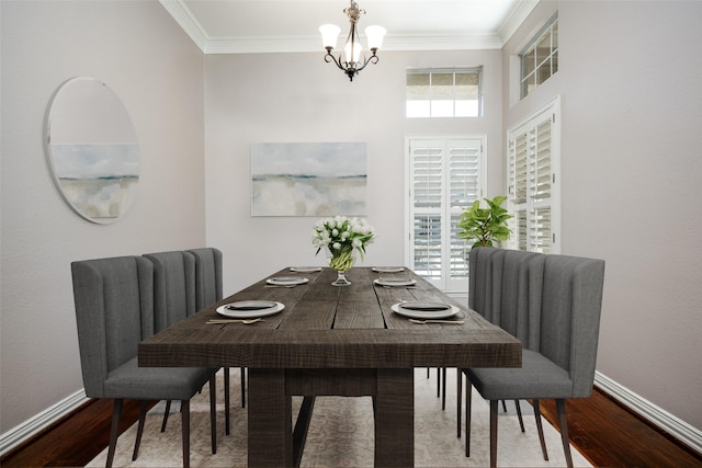 dining space with baseboards, a chandelier, wood finished floors, and ornamental molding