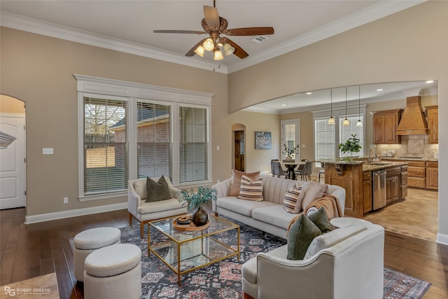 living room featuring ceiling fan, ornamental molding, and dark hardwood / wood-style flooring