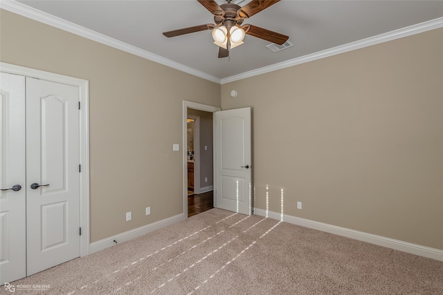 unfurnished bedroom featuring crown molding, ceiling fan, carpet flooring, and a closet