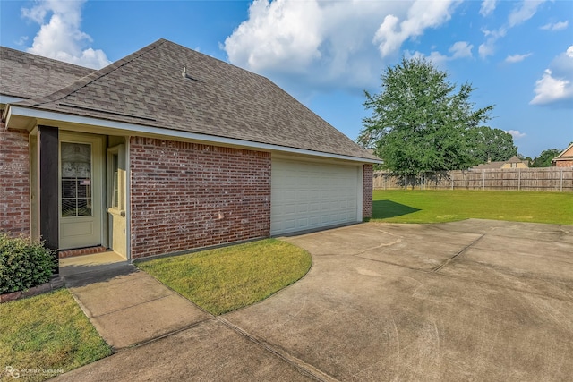 exterior space featuring a garage and a yard