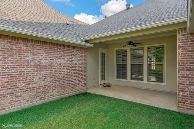 property entrance featuring ceiling fan, a patio, and a lawn