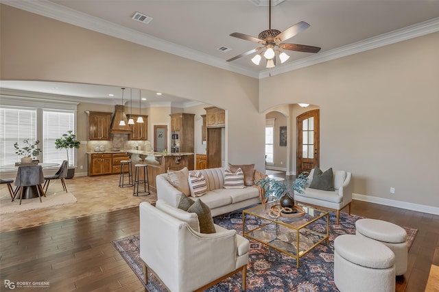 living room featuring crown molding, ceiling fan, and light hardwood / wood-style flooring