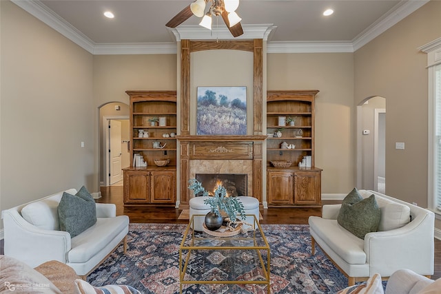 living room featuring a premium fireplace, crown molding, and dark hardwood / wood-style flooring