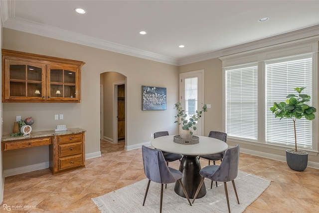 dining room featuring ornamental molding, a healthy amount of sunlight, and built in desk