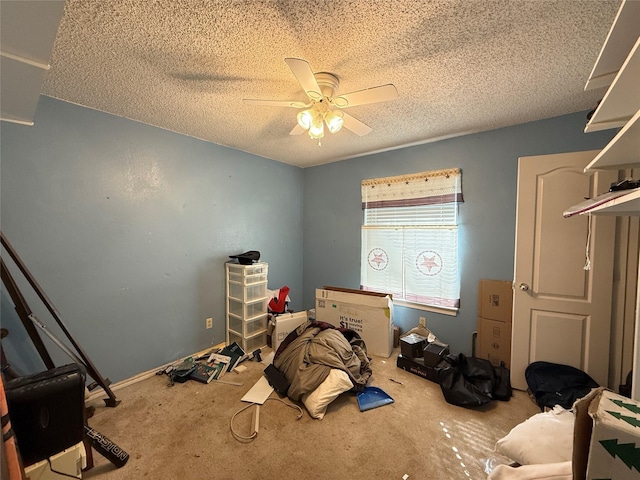 unfurnished bedroom with carpet, a ceiling fan, and a textured ceiling