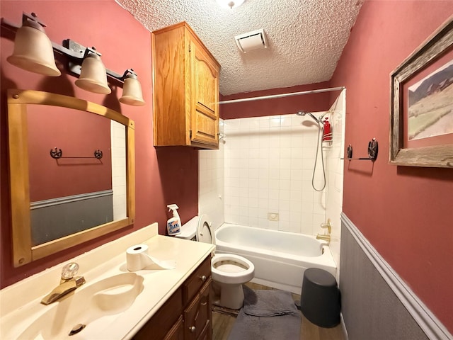 full bath featuring visible vents, toilet, shower / tub combination, a textured ceiling, and vanity