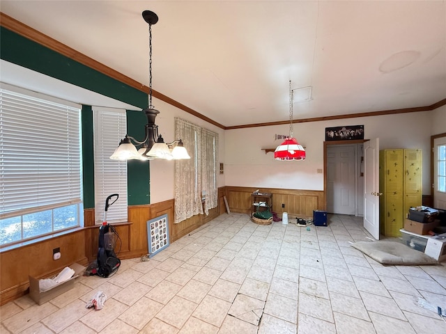 dining room featuring a wealth of natural light, a wainscoted wall, crown molding, and wood walls